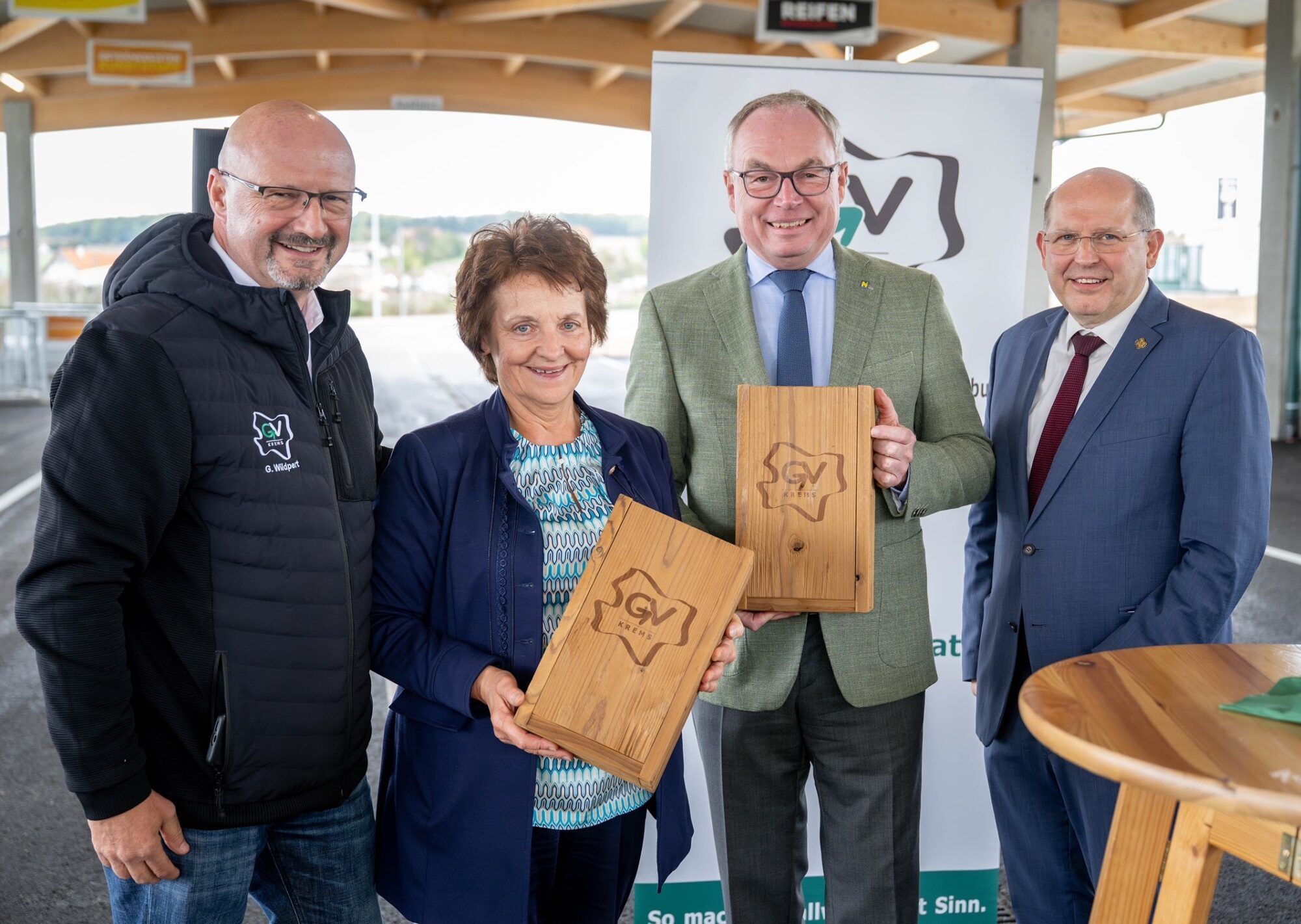 Die im Bildtext genannten Personen stehen im Wertstoffzentrum Gföhl und erhalten Holzkisten mit GV Krems Logo und Weinflaschen als Dank