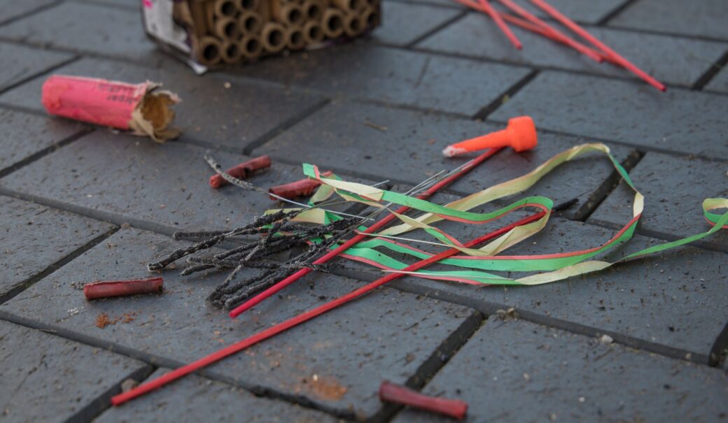 Das Foto zeigt Rückstünde und Abfall von Feuerwerkskörpern und Böllern, die auf einem Steinboden liegen.