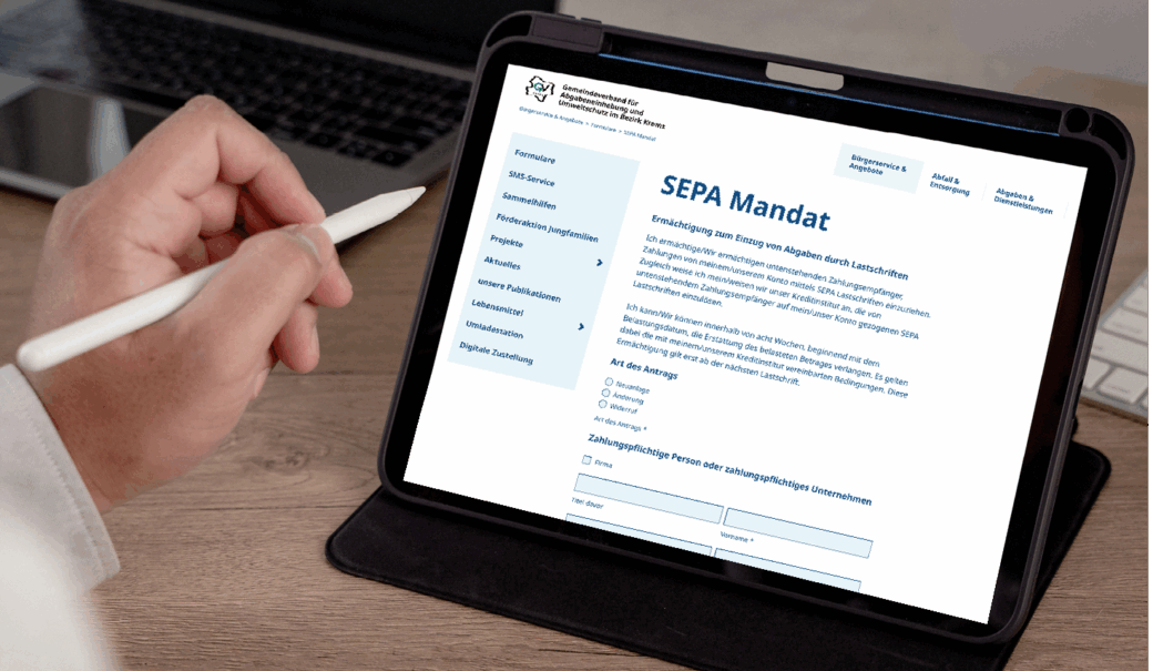 Tablett auf einem Tisch, 2 Hände sind sichtbar, eine davon hält einen weißen Schreibstift für das Tablet. auf dem Tablet sieht man das Online-Formular zum Erteilen eines SEPA-Mandats auf der Website des GV Krems