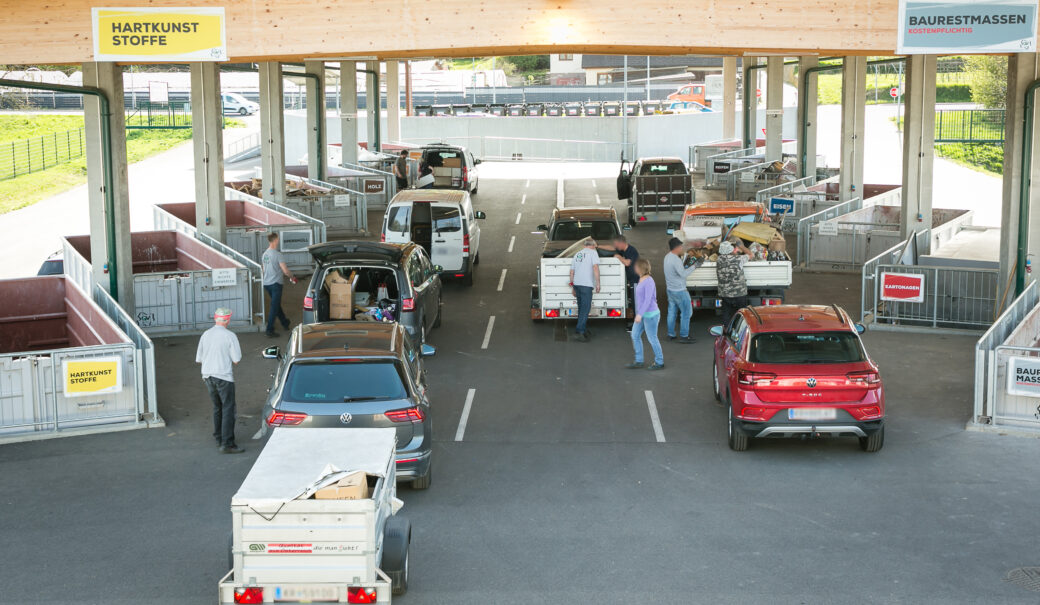 Blick auf das WSZ Langenlois, etwas von oben, man sieht einige Autos und Menschen, die in die Container links und rechts ihren Abfall getrennt entsorgen